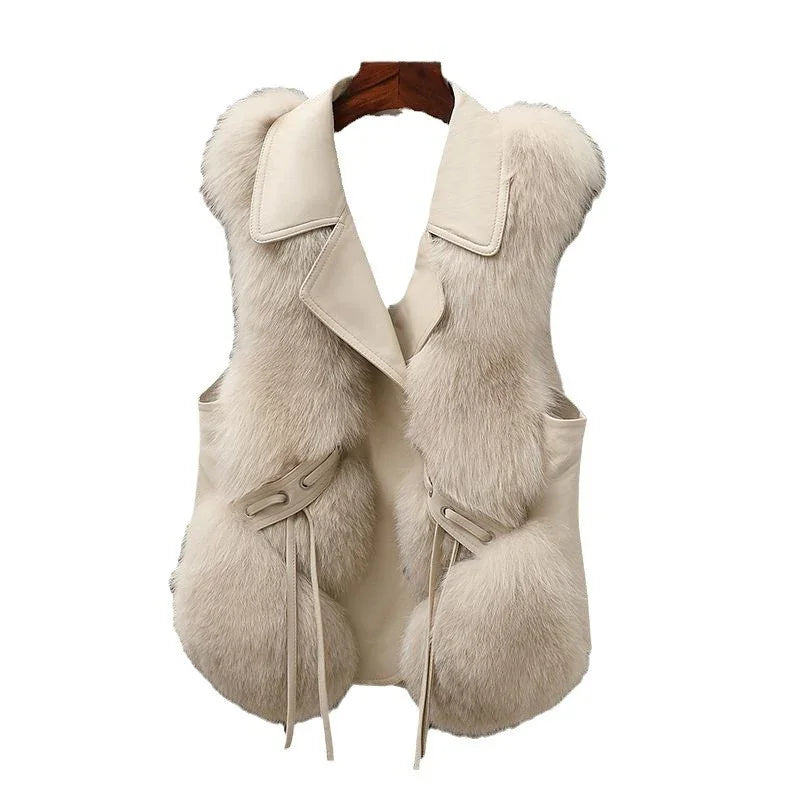 Beige sleeveless fur vest with wide collar and tie accents on white background