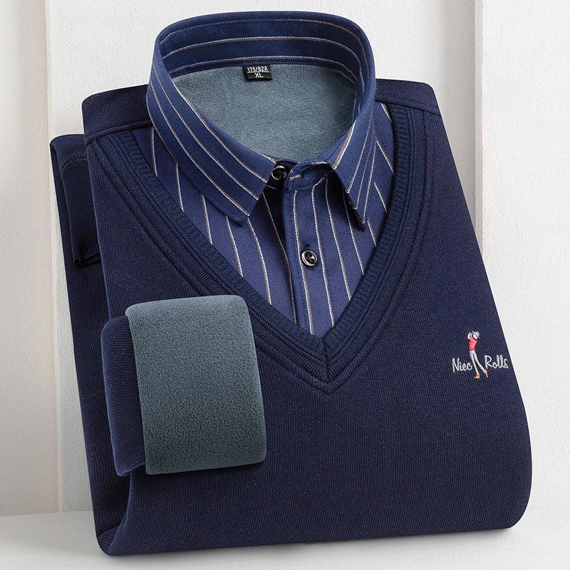 Folded navy blue sweater with V-neck over striped blue dress shirt on a light surface
