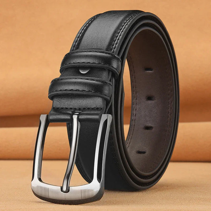Black leather men's belt with silver metal buckle on beige background