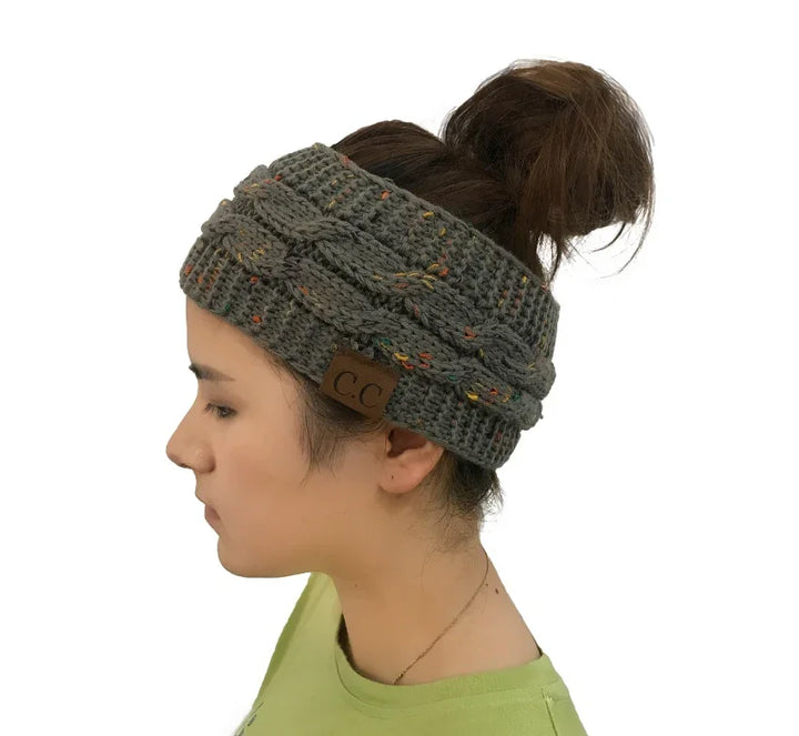Woman wearing gray knitted cable headband with ponytail, green shirt, side profile