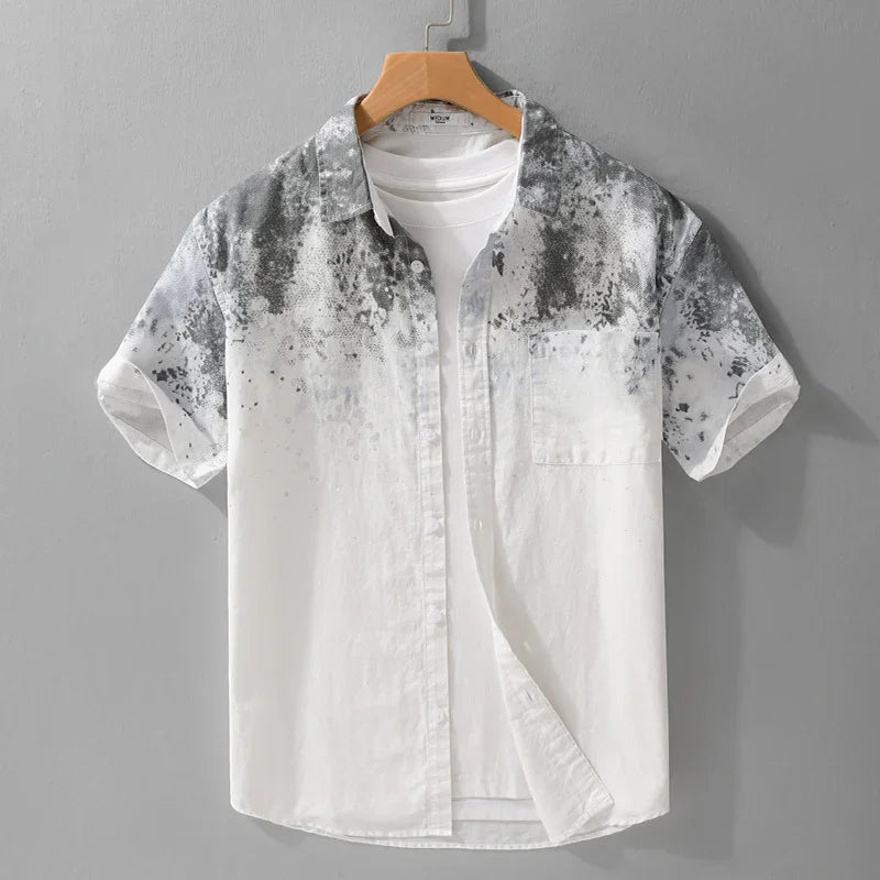 Men's short sleeve white shirt with black watercolor pattern on shoulders and chest, displayed on hanger
