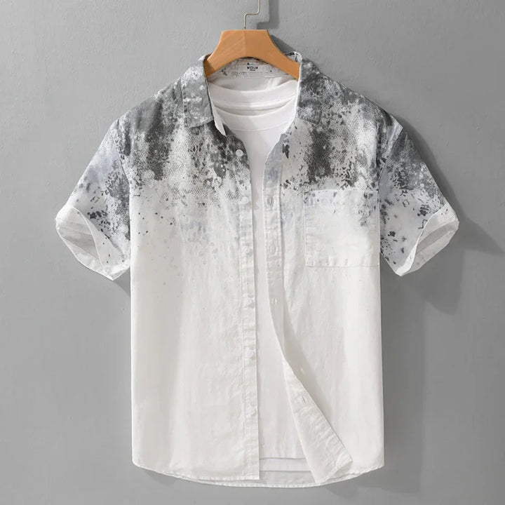 Men's short sleeve white shirt with black watercolor pattern on shoulders and chest, displayed on hanger