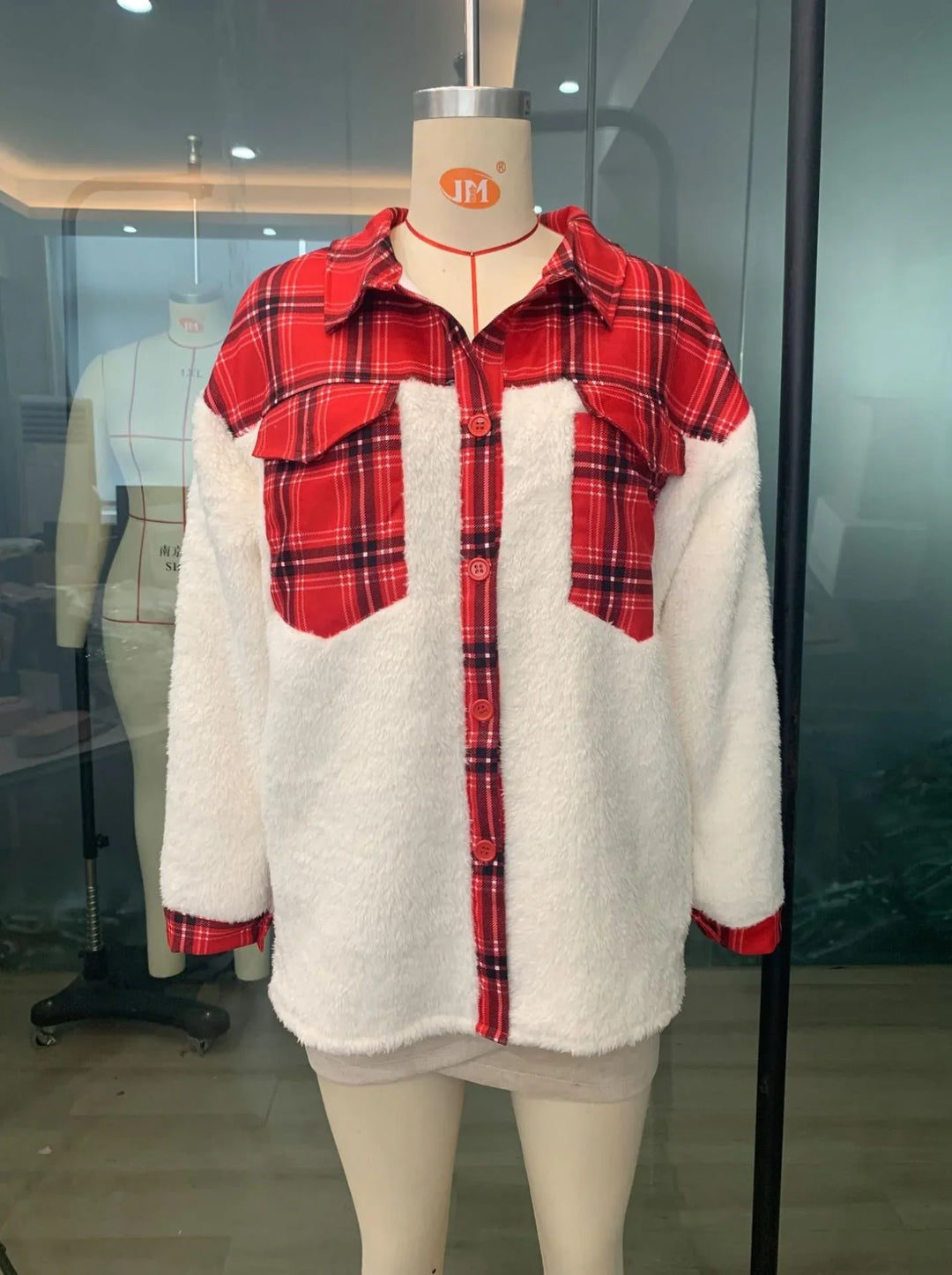 Red plaid and white sherpa fleece jacket on mannequin in showroom