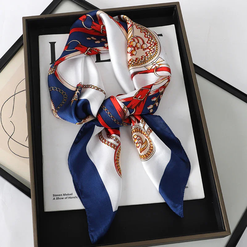 Silky navy blue and white scarf with red and gold chain patterns, displayed in black gift box
