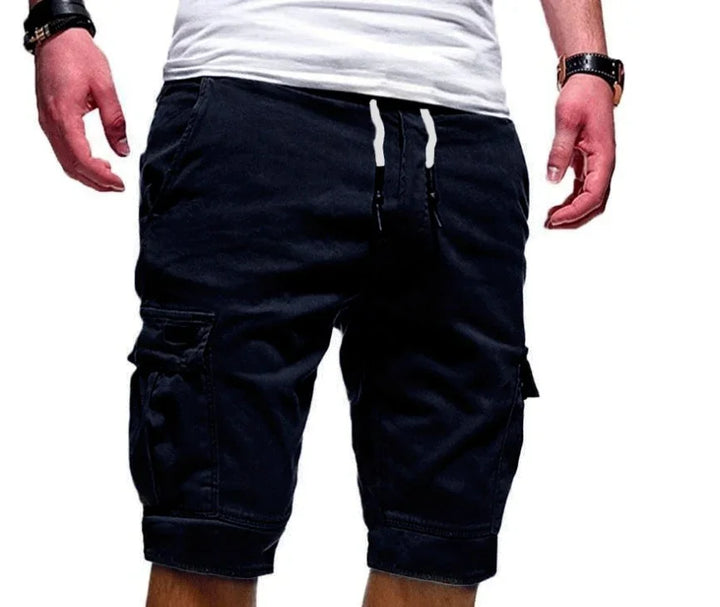 Man wearing black cargo shorts and white t-shirt with wristwatch on white background