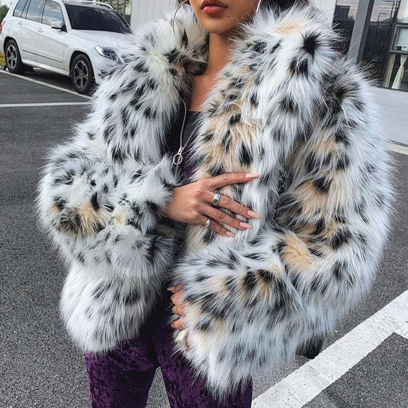 Woman wearing a white and black spotted faux fur coat with tan accents in an urban parking lot