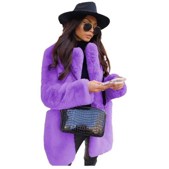 Woman wearing purple faux fur coat, black hat, sunglasses, and holding black textured handbag while using smartphone