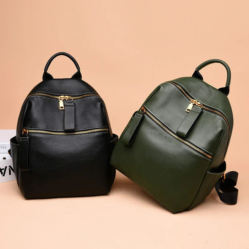 Black and green leather backpacks with gold zippers on a beige background, stylish small travel bags
