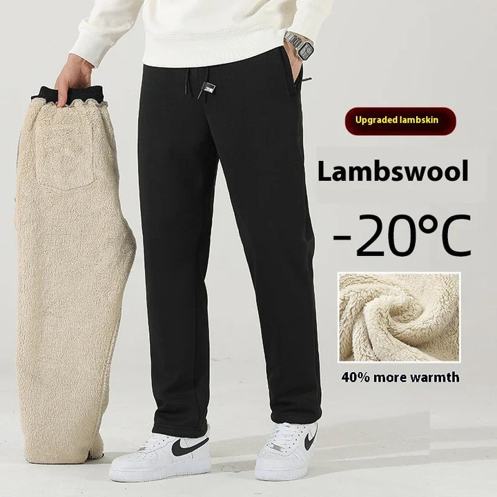 Man wearing black lambswool pants holding beige upgraded lambskin pants, highlighting warmth for -20°C