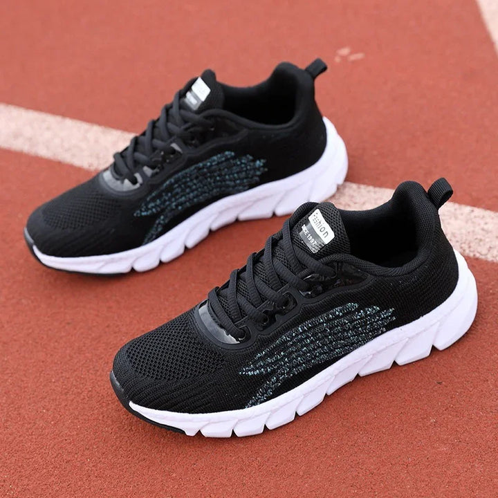 Black running shoes with white thick soles on an outdoor track surface