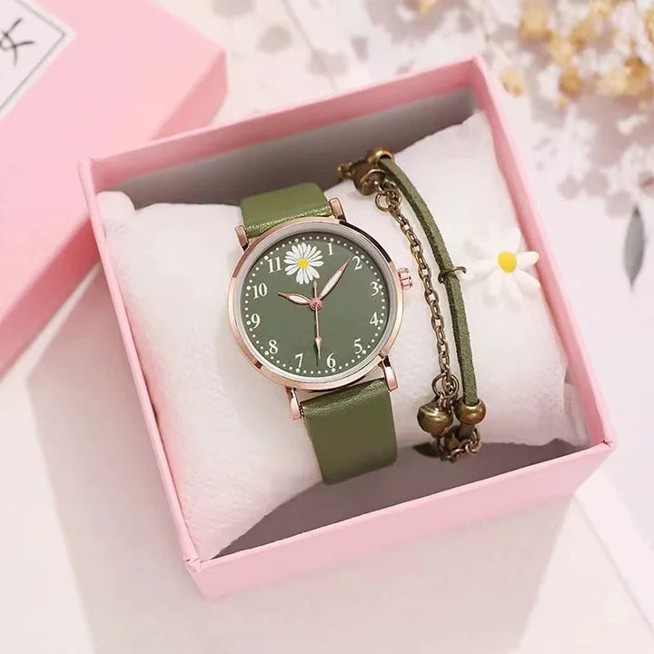 Green wristwatch with daisy design and matching charm bracelet in pink gift box on white pillow