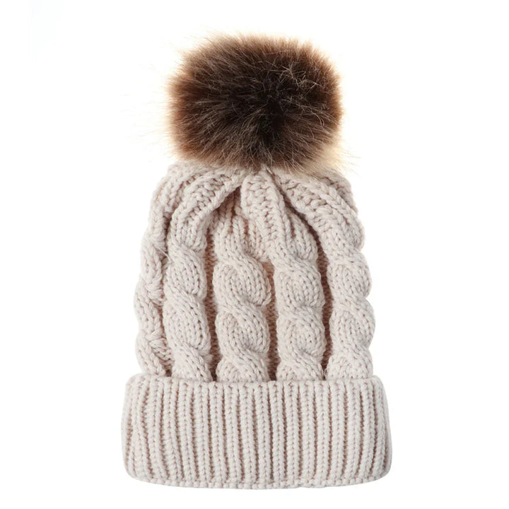 Beige cable knit winter beanie with folded cuff and brown faux fur pom pom
