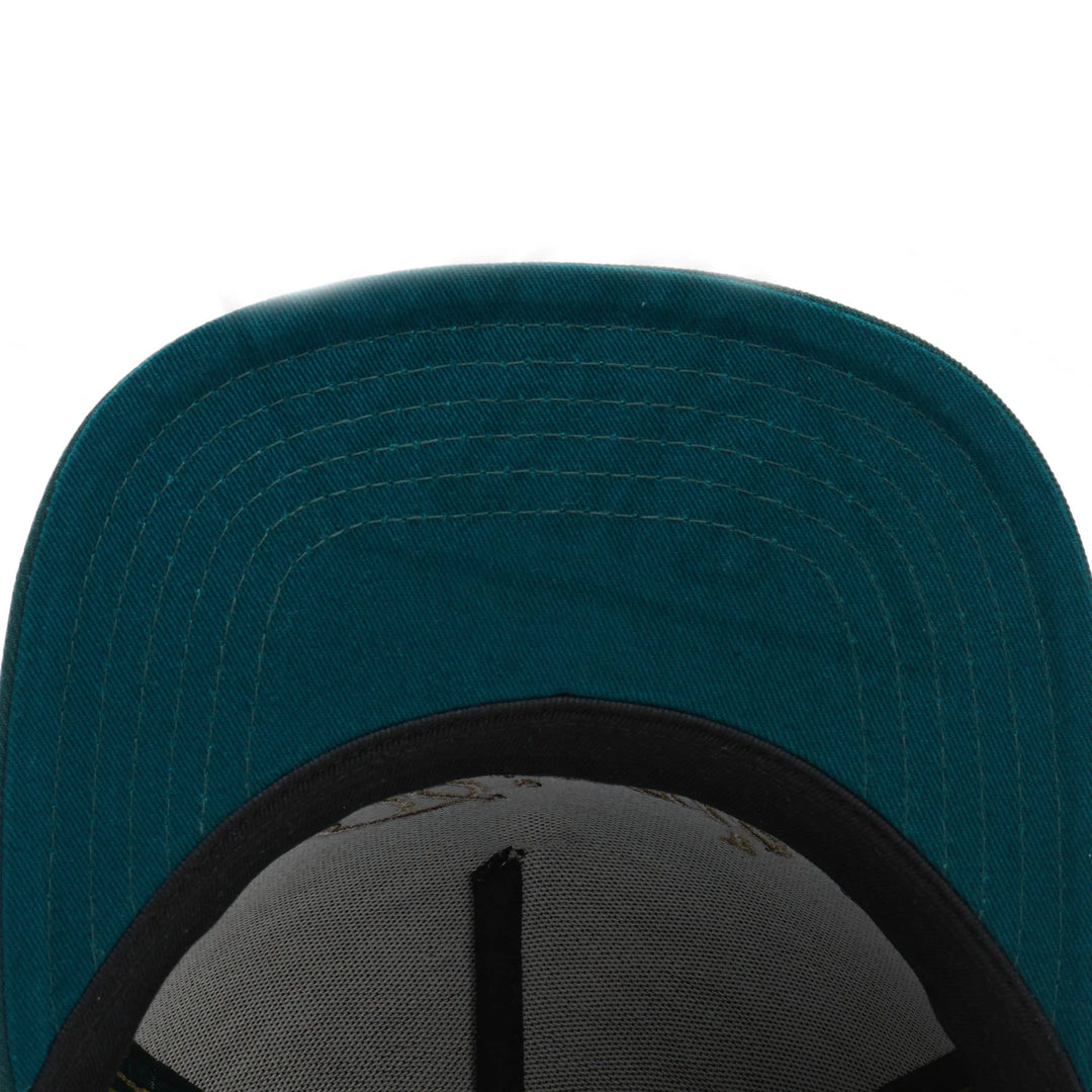 Close-up of teal green fabric cap brim with black inner band and white mesh lining