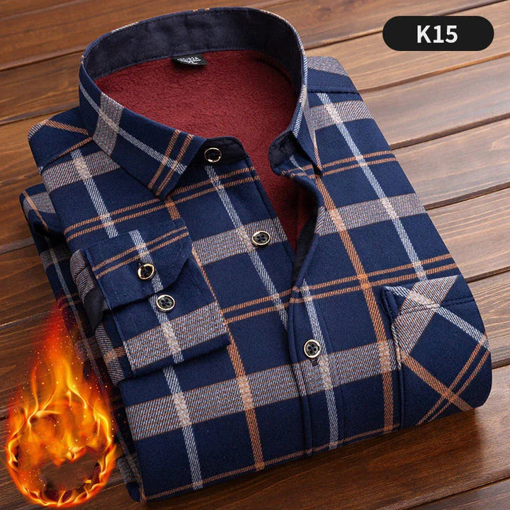 Folded navy blue plaid flannel shirt with red fleece lining, displayed on wood surface