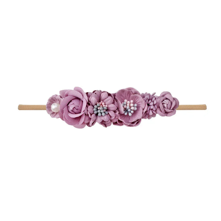 Pink fabric flower headband with pearls and floral embellishments on a neutral band