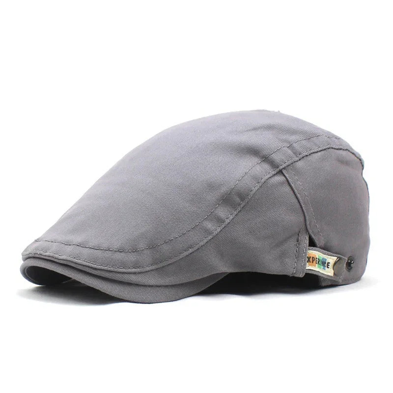 Gray cotton flat cap with stitched details and small tag on side against white background