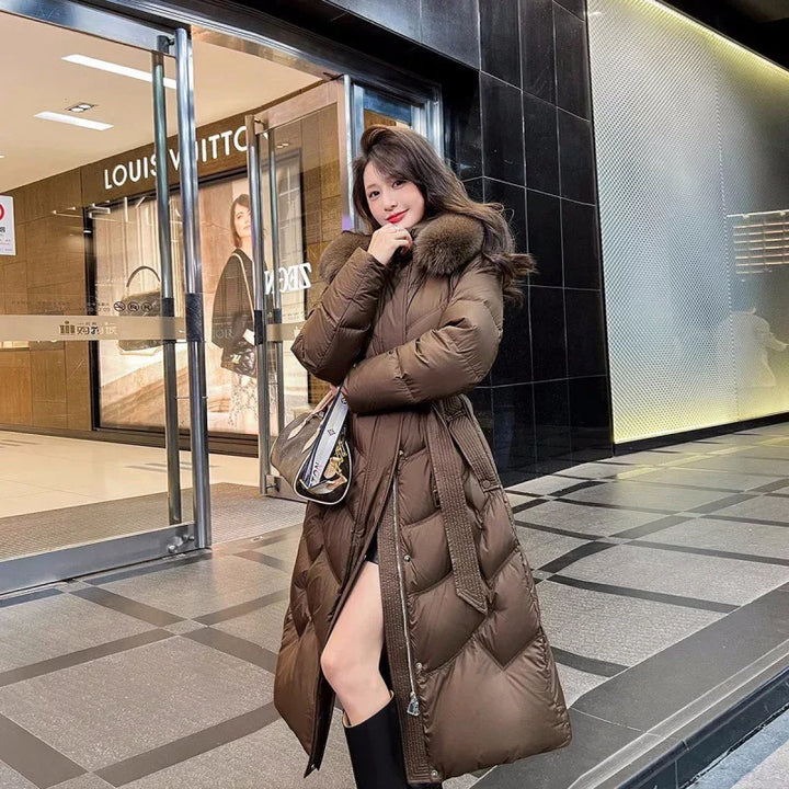 Woman wearing long brown puffer coat with fur collar standing outside Louis Vuitton store