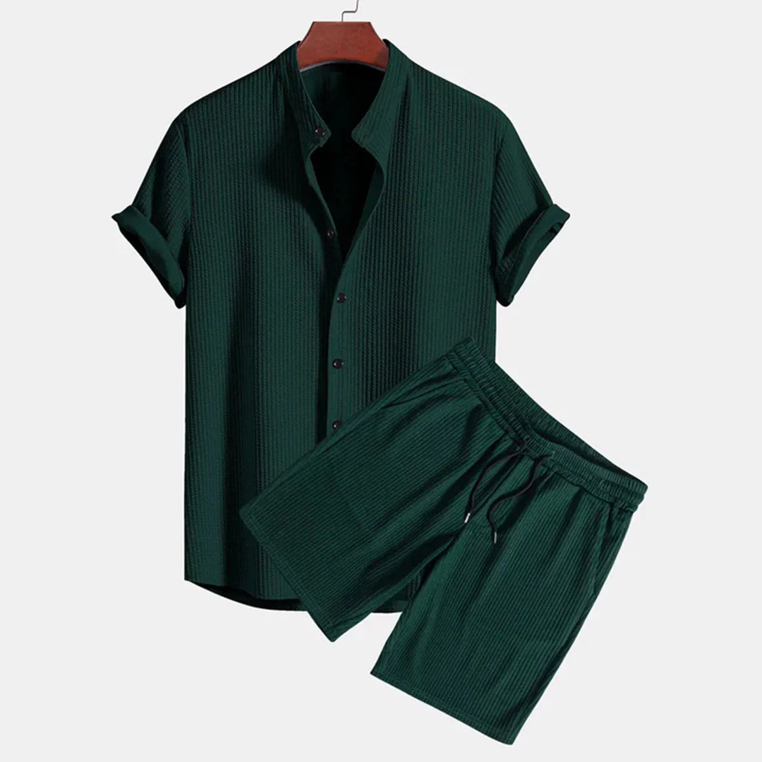 Dark green textured short sleeve button-up shirt with matching drawstring shorts on hanger