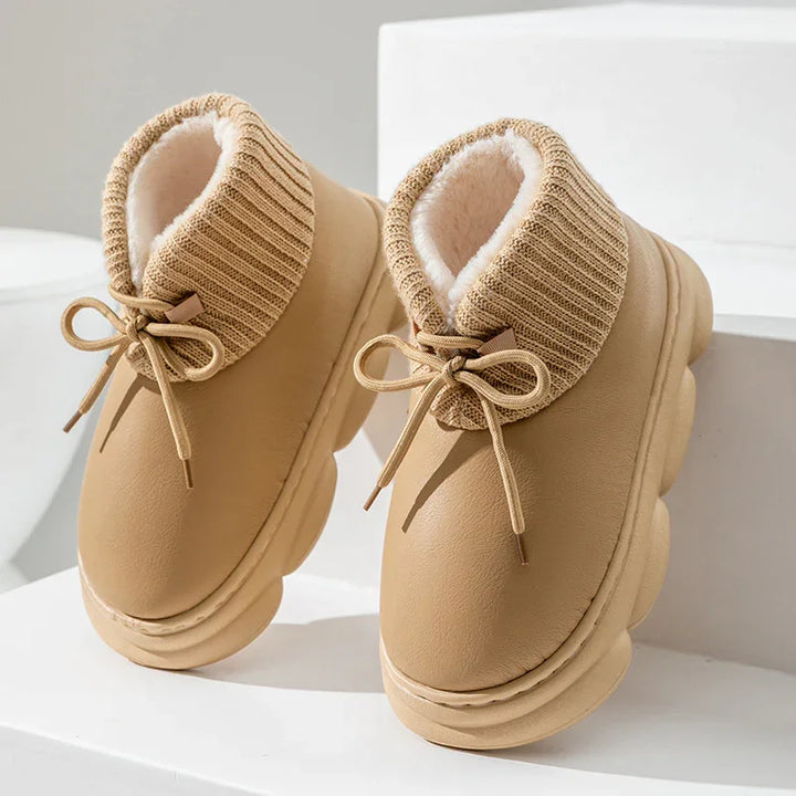 Beige winter boots with thick knit cuffs and fluffy white interior lining on white steps