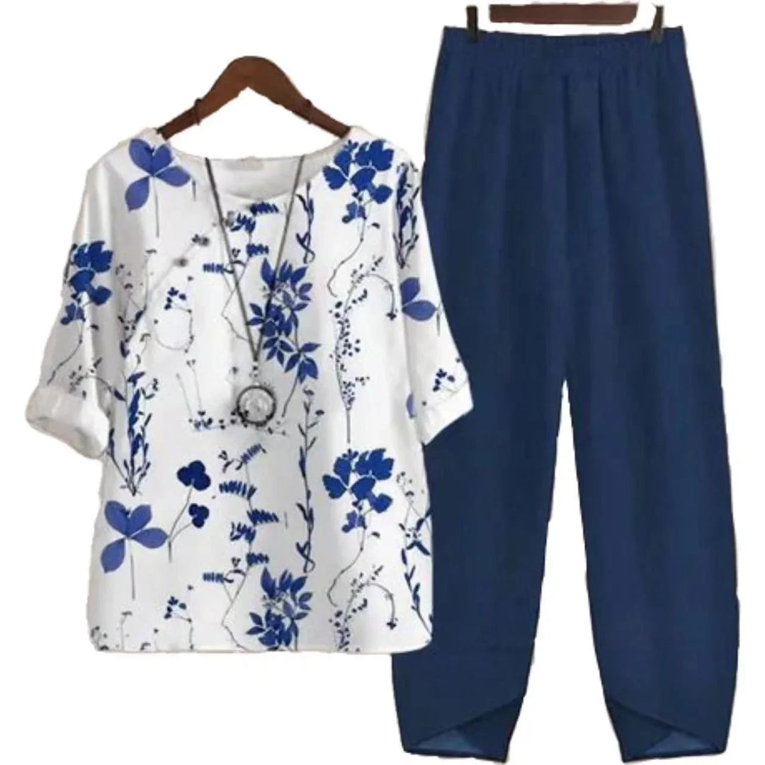 White blouse with blue floral print and navy blue elastic waist pants outfit on hangers