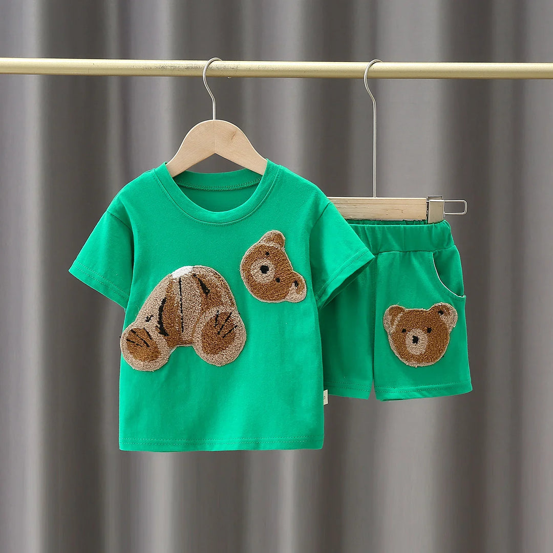Green toddler outfit with short sleeves and shorts featuring textured teddy bear patch design