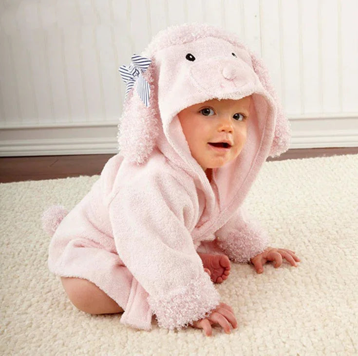 Baby crawling on carpet wearing pink lamb hooded robe with ears and striped bow