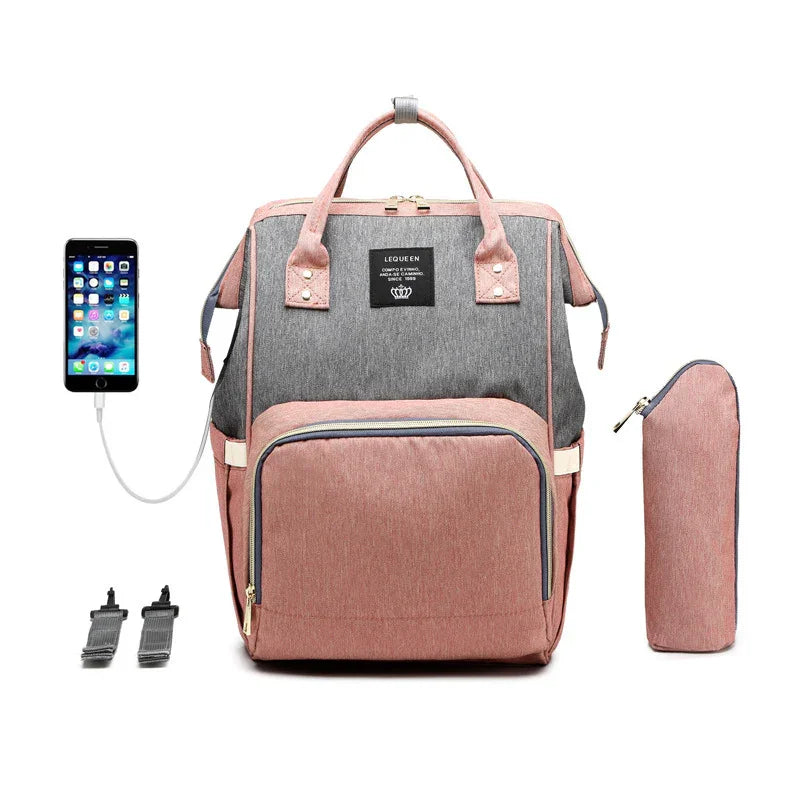 pink and grey LEQUEEN diaper backpack with USB charging port, bottle holder, and phone connected