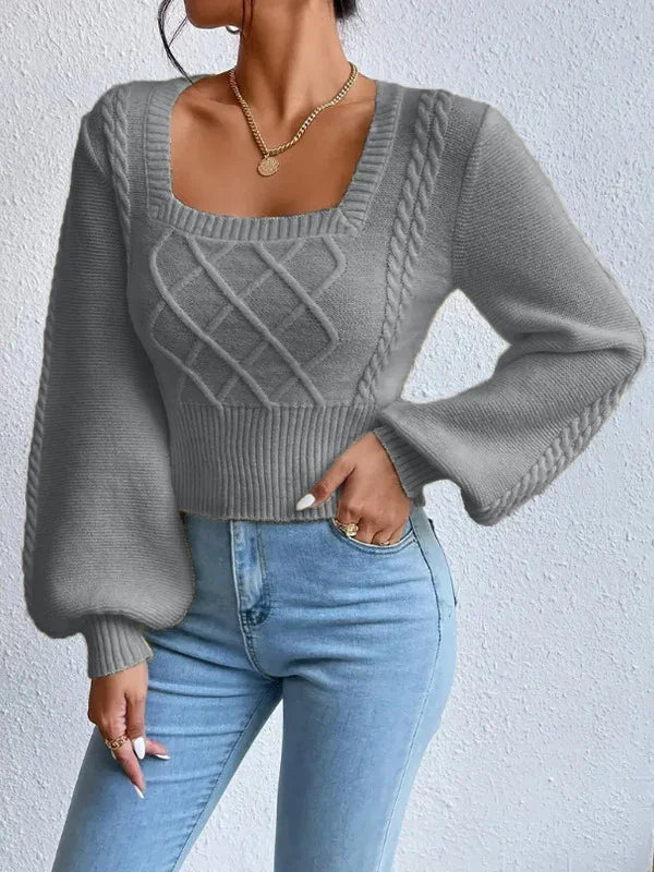 Woman wearing gray cable knit square neck sweater with balloon sleeves and light blue jeans