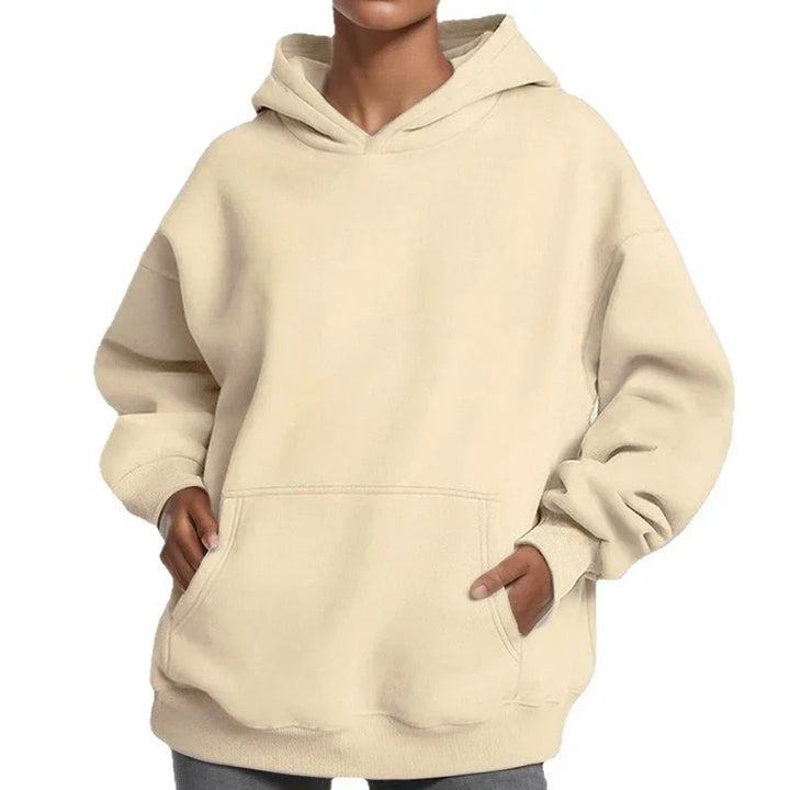 Beige oversized hoodie with front kangaroo pocket worn by person, casual streetwear