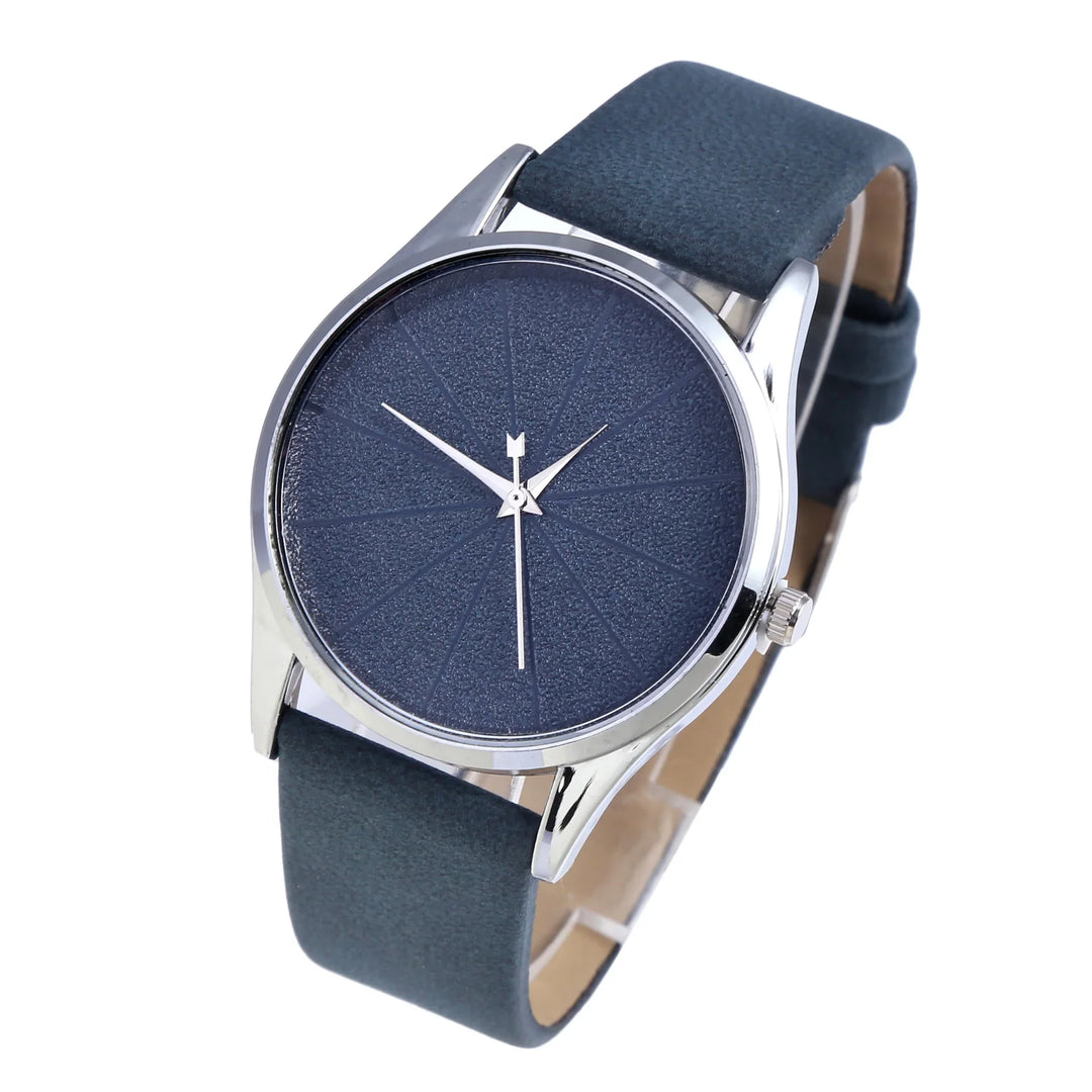 Minimalist men's wristwatch with textured navy blue dial, silver case, and dark blue leather strap