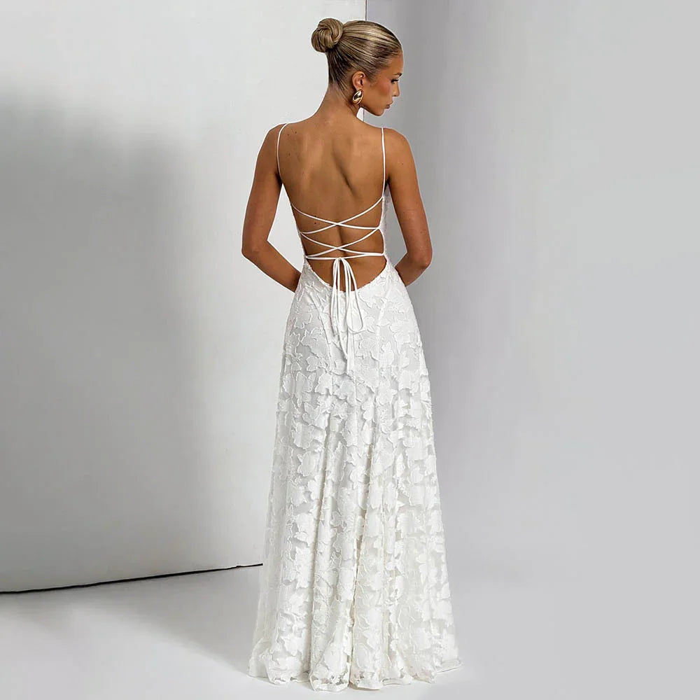 Back view of woman in a white lace sleeveless gown with crisscross straps and bun hairstyle