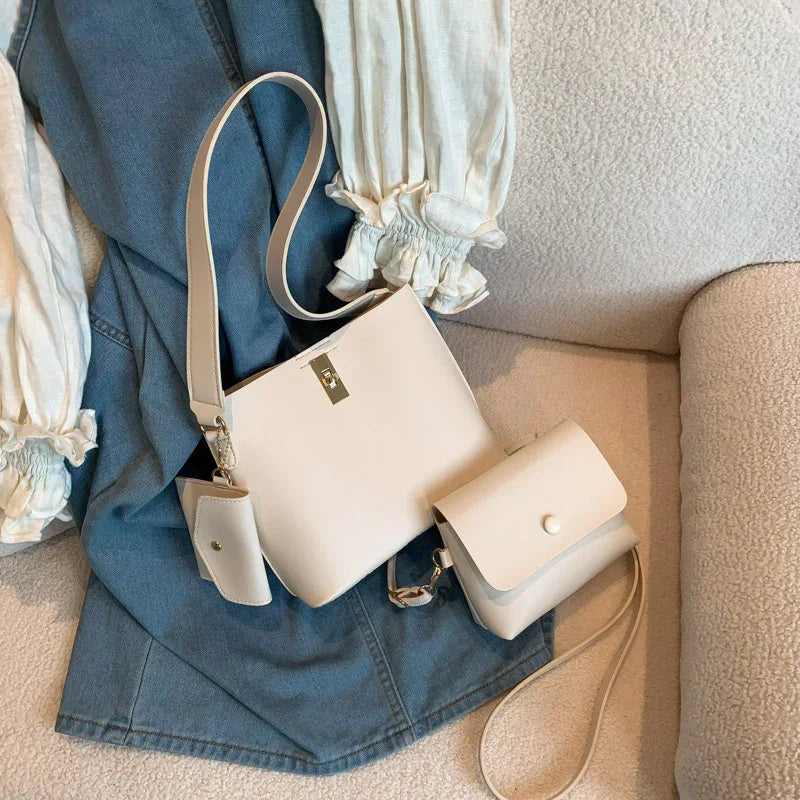 White leather shoulder bags and cream blouse with ruffled sleeves on blue denim skirt and beige textured chair