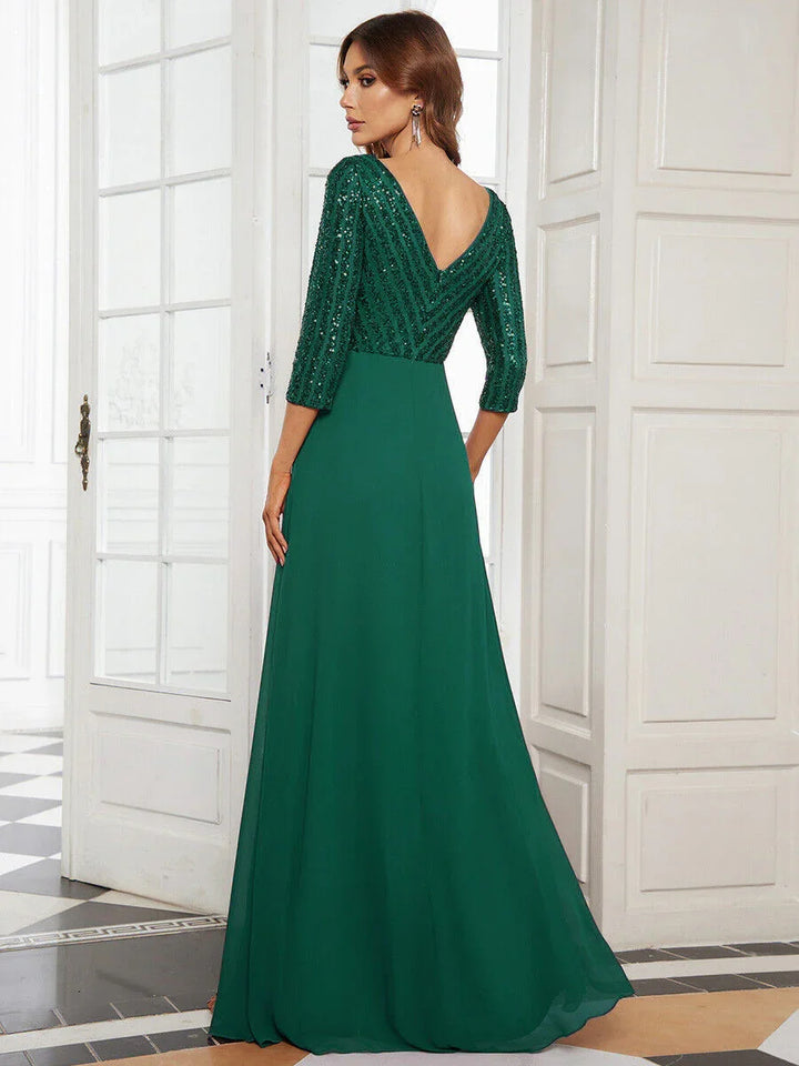 Woman in elegant green evening gown with sequin top and long skirt posing indoors