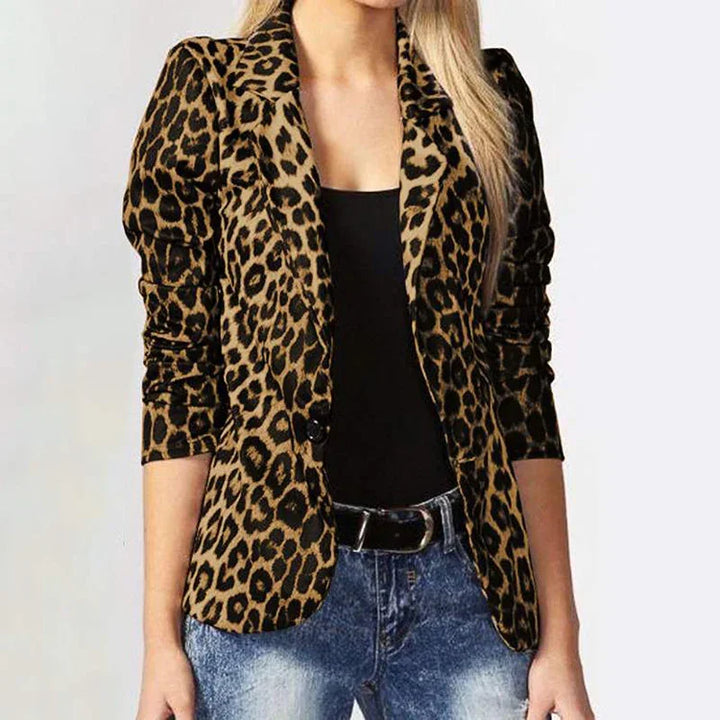 Woman wearing a leopard print blazer with ruched sleeves, black top, and blue jeans