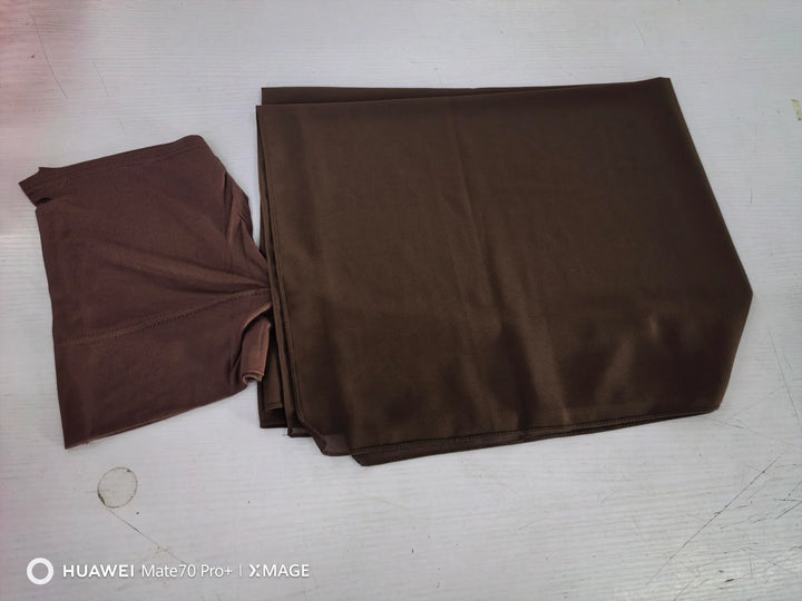 Brown folded fabric and matching brown stretch fabric on white surface