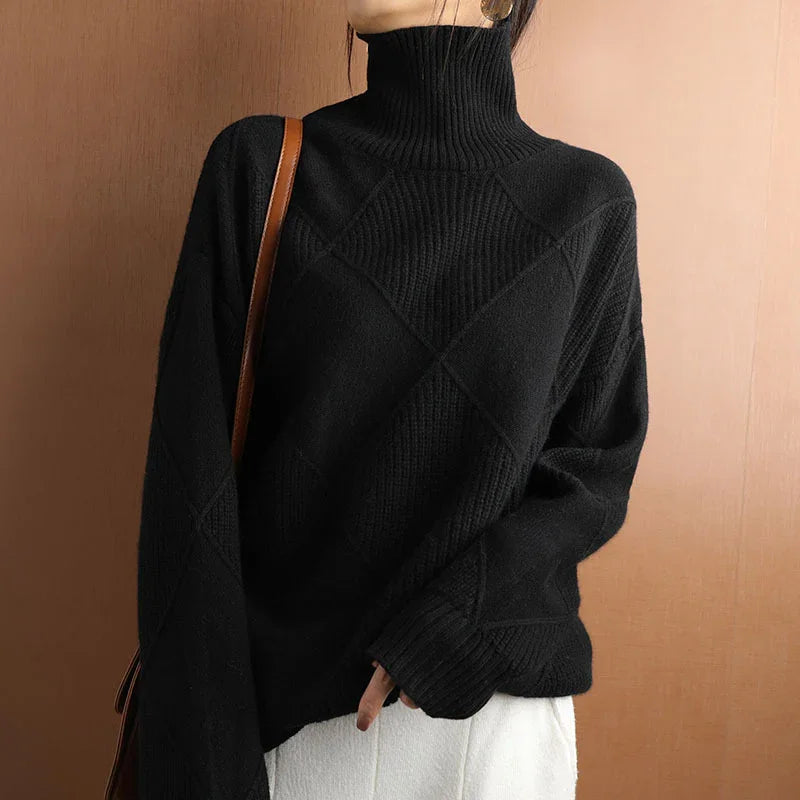 Woman wearing a black turtleneck knit sweater with white pants and brown shoulder bag
