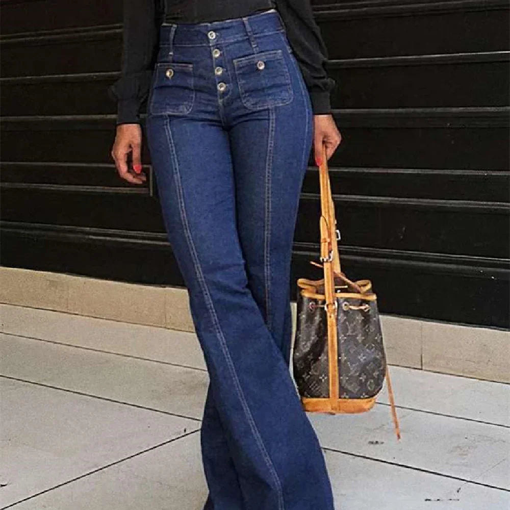 Person wearing high-waisted blue denim jeans with buttons, holding brown designer bag with leather straps