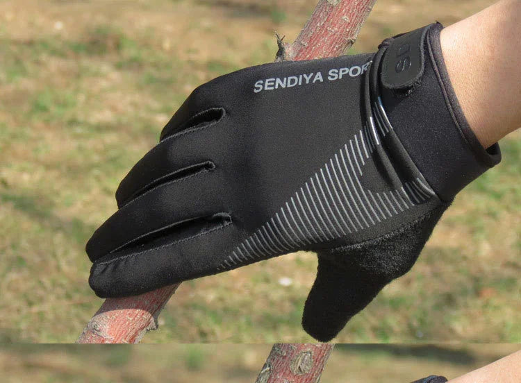 Close-up of hand wearing black SENDIYA SPORT glove holding a tree branch outdoors on grass background