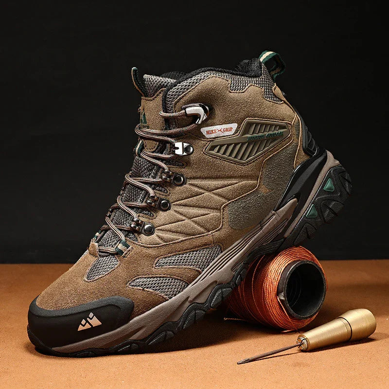 Brown and black hiking boot with rugged sole and lace-up design, displayed on brown surface with spool and tool