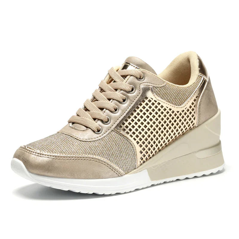 Beige women's wedge sneaker with mesh panels, lace-up front, and white sole