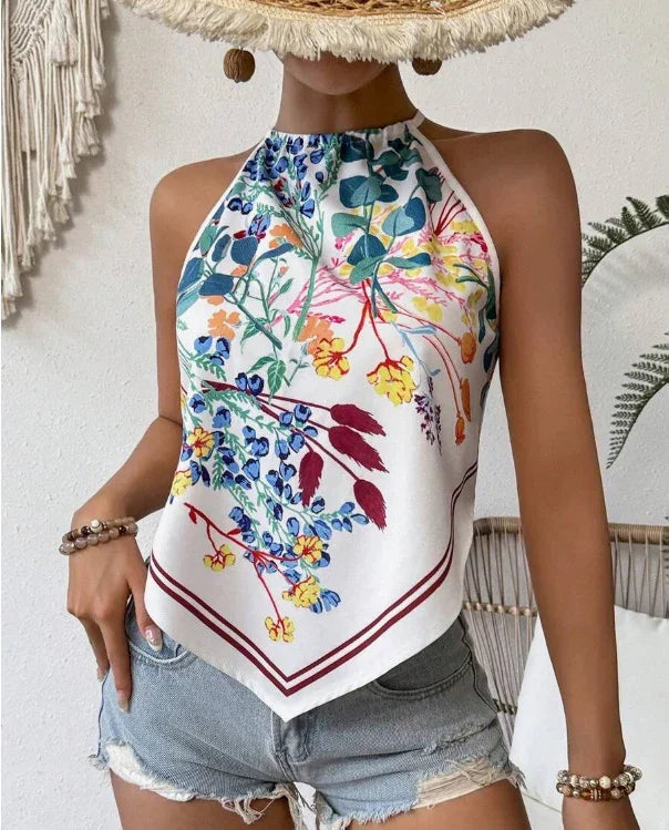 Woman wearing sleeveless halter neck floral print top with denim shorts and boho accessories