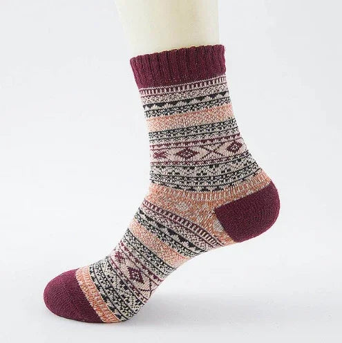 Maroon and peach patterned wool sock with geometric designs on mannequin foot