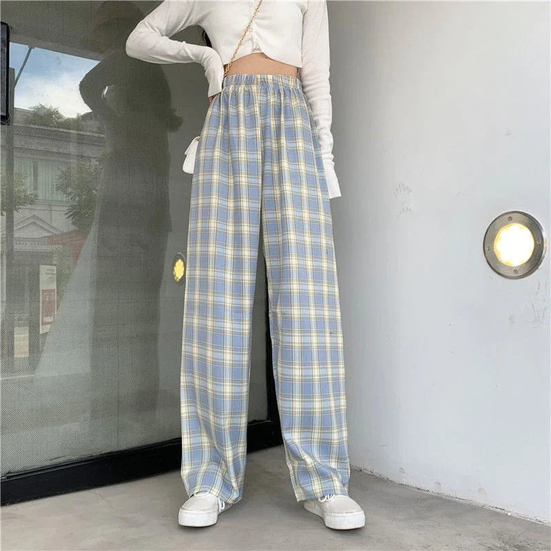 Woman wearing high-waisted blue and yellow plaid wide-leg pants with white sneakers and cropped long-sleeve top