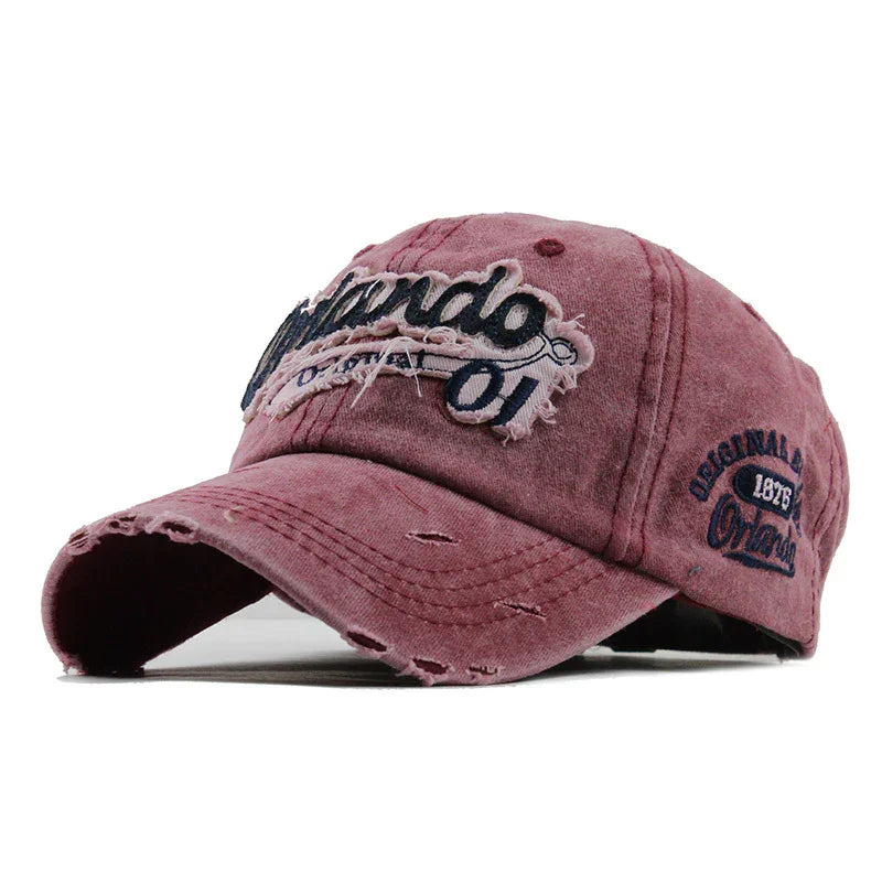 Distressed pink Orlando baseball cap with embroidered text and worn fabric details