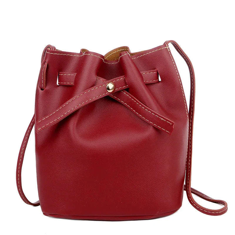 Red leather bucket bag with drawstring closure and stitched detailing