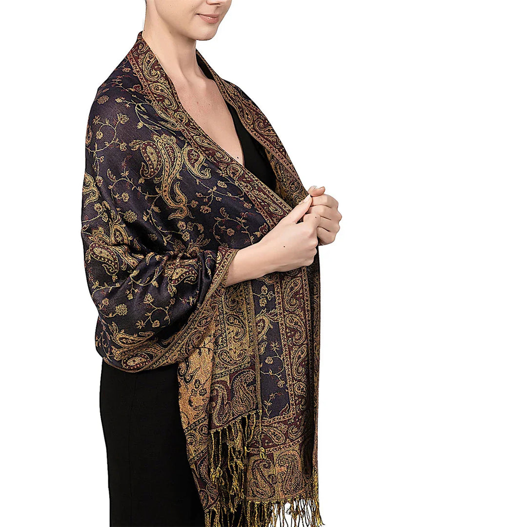 Woman wearing a black dress and luxurious dark blue paisley patterned shawl with gold accents and fringes
