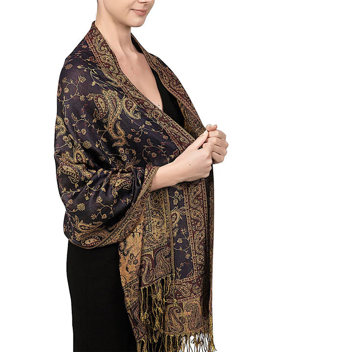 Woman wearing a black dress and luxurious dark blue paisley patterned shawl with gold accents and fringes