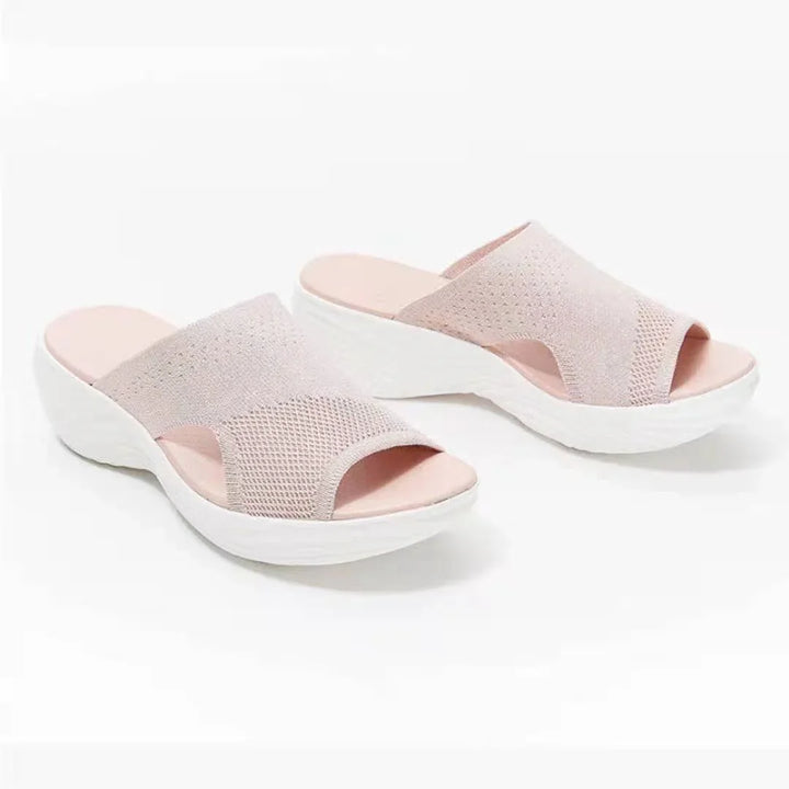 Women's pink knit slip-on sandals with white wedge soles on white background