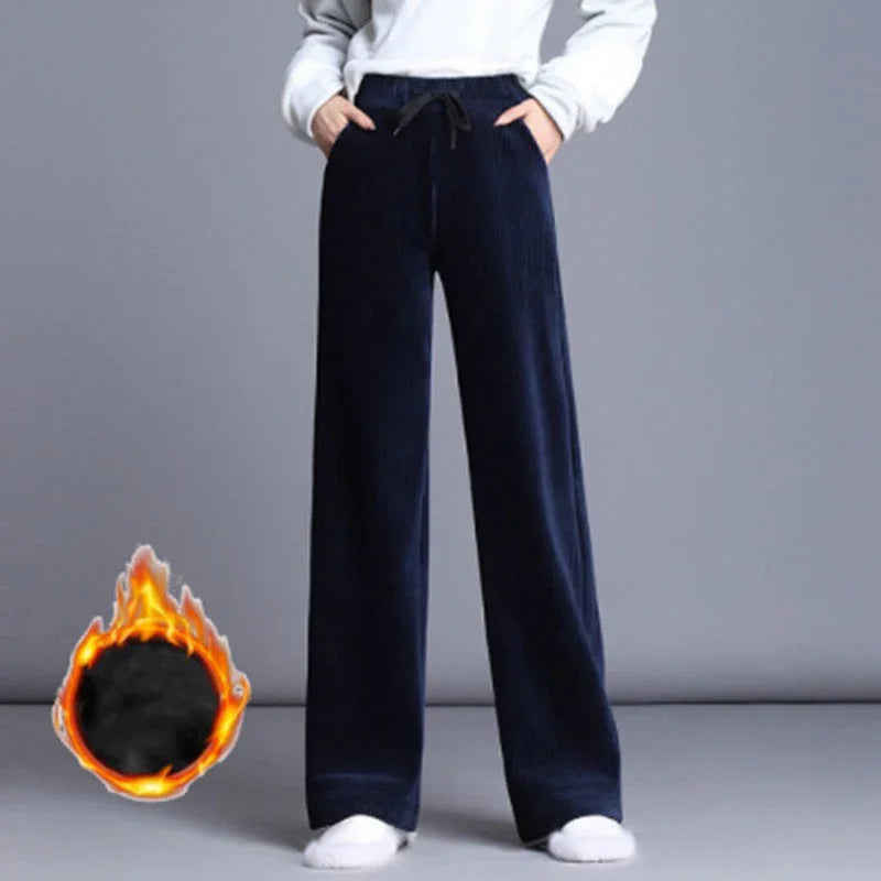 Person wearing navy blue corduroy wide-leg pants with drawstring and white sneakers