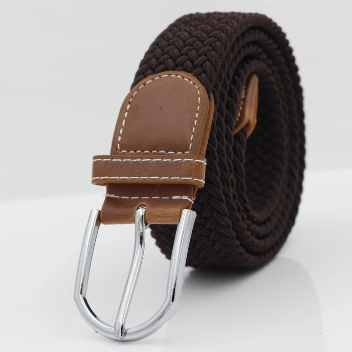 Brown woven fabric belt with tan leather end and silver metal buckle on white background